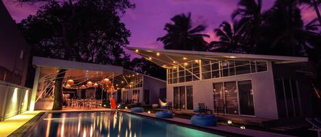 Vista frontal de la propiedad por la tarde o noche