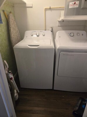 A laundry room with two white washing machines, a green wall, and a wooden floor. - Great Location for your vacation.  Very Pet Friendly!. Close to Boardwalk/Beach. (Ocean City)