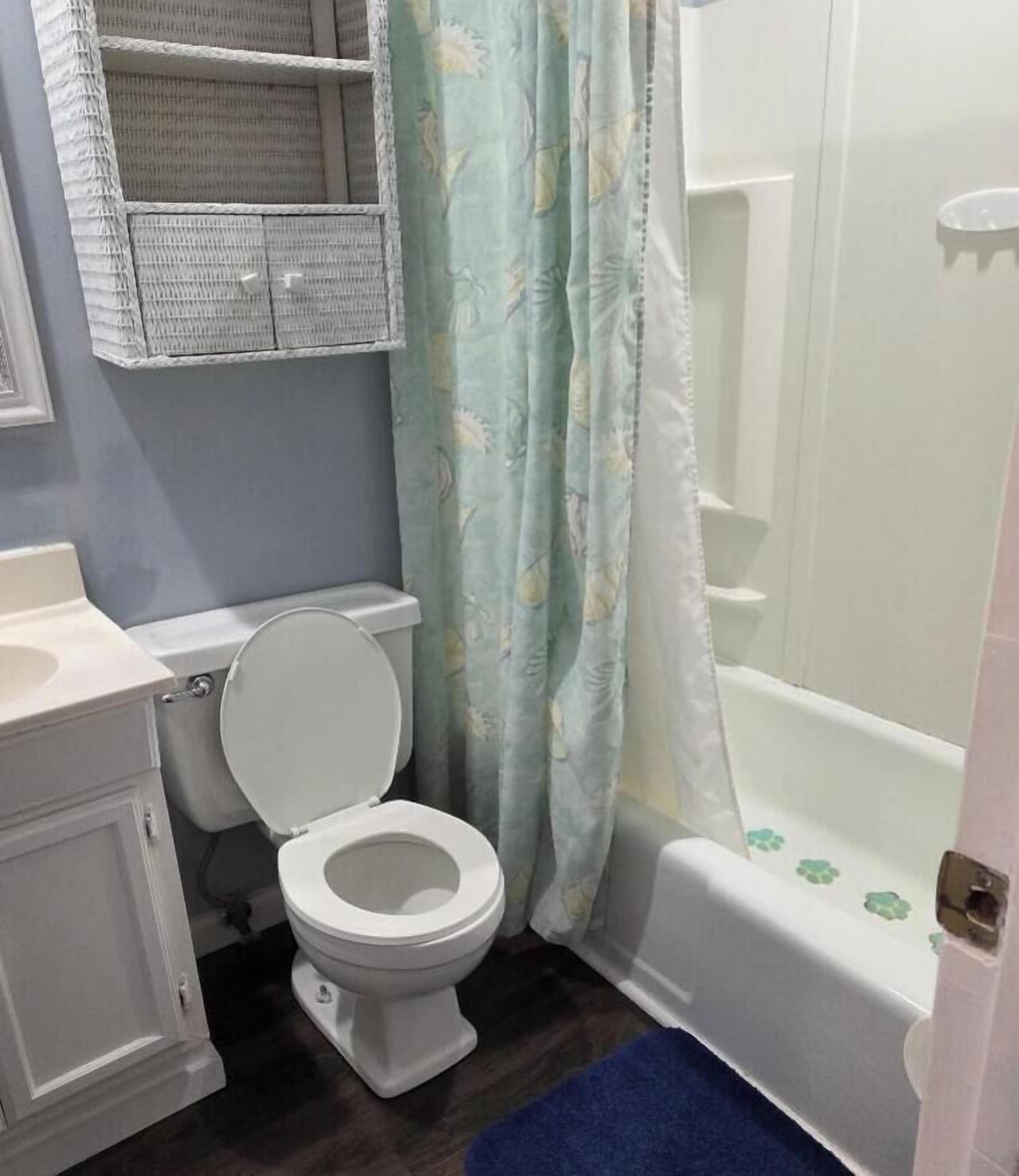 A bathroom with a toilet, a bathtub, and a shower curtain.