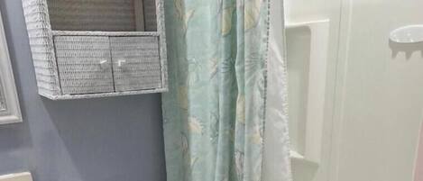 A bathroom with a toilet, a bathtub, and a shower curtain.