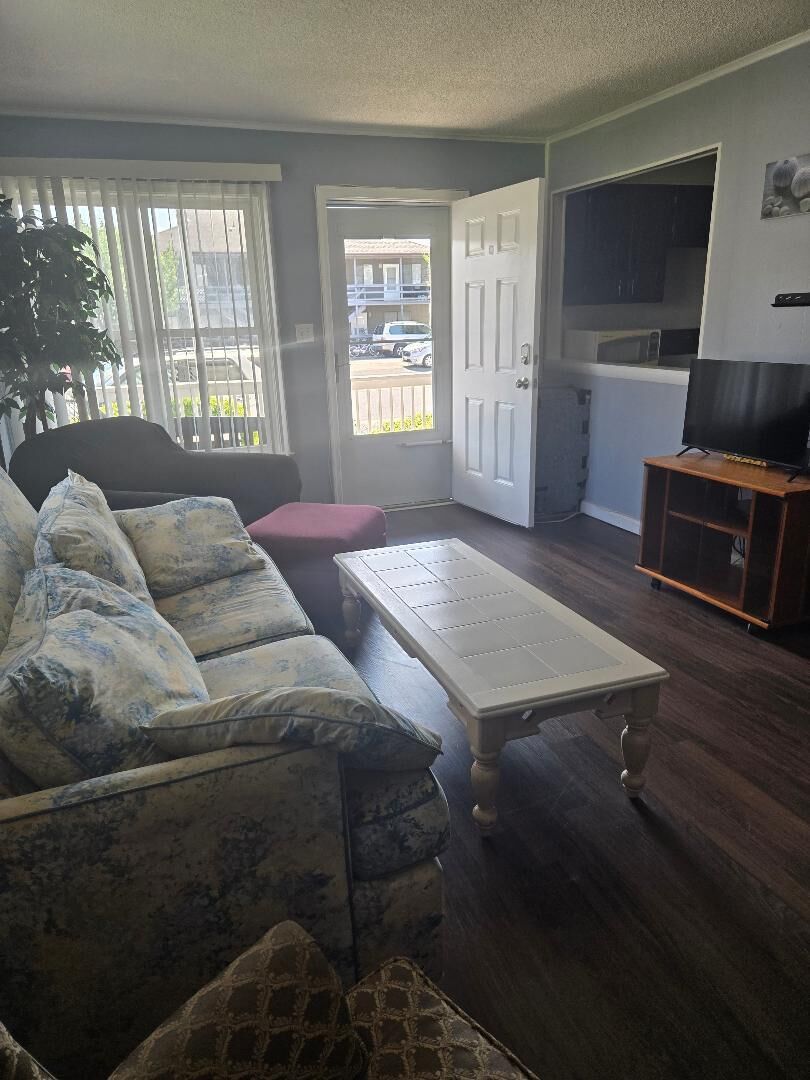 A living room with a sofa, a coffee table, and a TV stand.