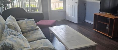 A living room with a sofa, a coffee table, and a TV stand.
