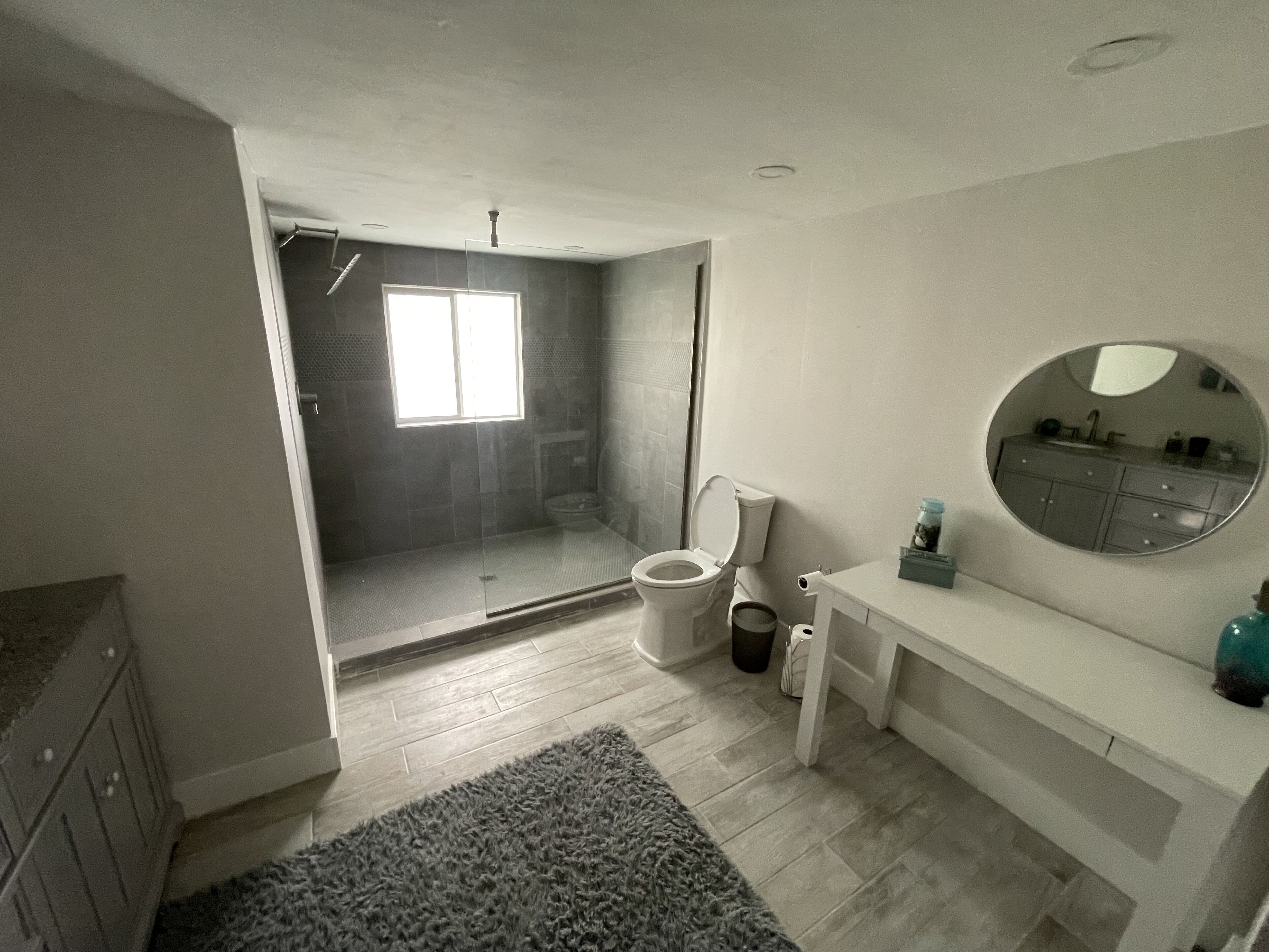 A modern bathroom with a shower, toilet, and vanity.