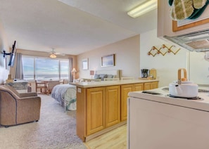 Enjoy a comfortable stay in this well-appointed room with a large bed, sofa, and kitchenette, offering a scenic ocean view.