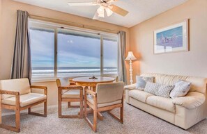 Enjoy ocean views from this room, featuring a round table, sofa, and comfortable seating for four.