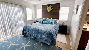 A bedroom with a bed, a turtle wall art, and a window with blinds. - Ocean View Townhome across from beautiful Amelia Island Beach (Fernandina Beach)