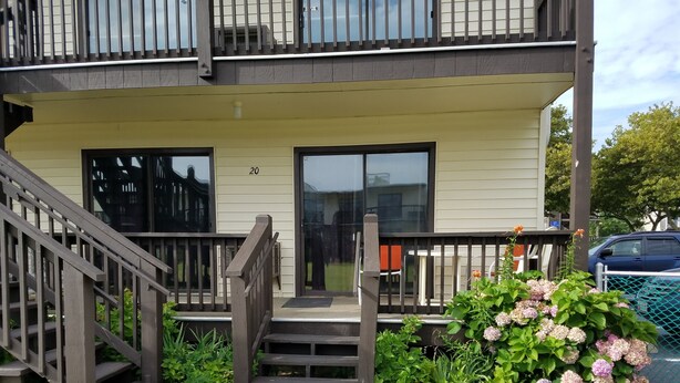A two-story building with a balcony, a staircase, and a number '20' on the door. - Great Location for your vacation.  Within walking distance to beach, restaurants (Ocean City)