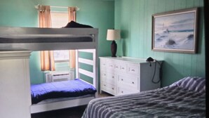 A bunk bed room with a window, a dresser, and a painting on the wall. - Great Location for your vacation.  Within walking distance to beach, restaurants (Ocean City)
