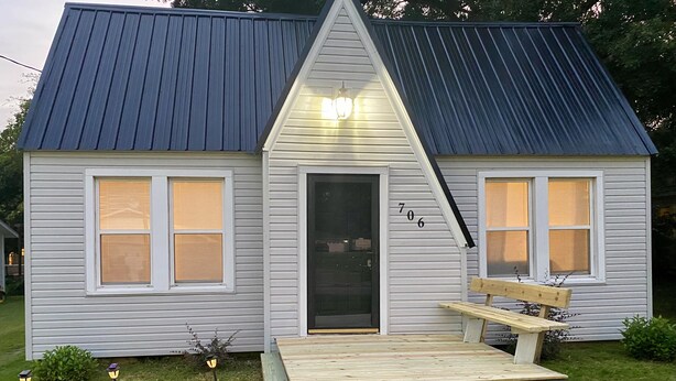 A small house with a blue roof, a front door, and a wooden bench outside. - Home Town Getaway - 2 bed 1 bath home - close to town! (Paris)