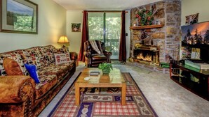 Ein gemütliches Wohnzimmer mit Kamin, Sofa, Couchtisch und Bücherregal.