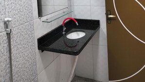 A bathroom with a black sink, a mirror, and a shower.