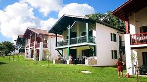 A hotel with a two-story structure, a covered patio area, and a well-maintained lawn.