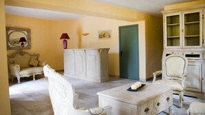 A room with a white sofa, a white cabinet, a white armchair, and a coffee table with decorative items. - Appart Duplex avec Climatisation | 2km de Gordes (Gordes)