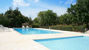 A rectangular swimming pool with two separate sections, surrounded by a tiled deck and white lounge chairs. - Appart Duplex en Provence | Piscine Saisonnière (Gordes)