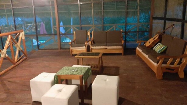 A rustic room with wooden furniture, including a sofa, chairs, and a table. - Amazon Journeys Lodge & Expedition (Indiana)