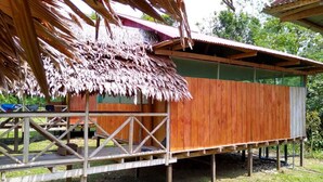 A wooden structure with a thatched roof, elevated on stilts, and a simple wooden deck. - Amazon Journeys Lodge & Expedition (Indiana)