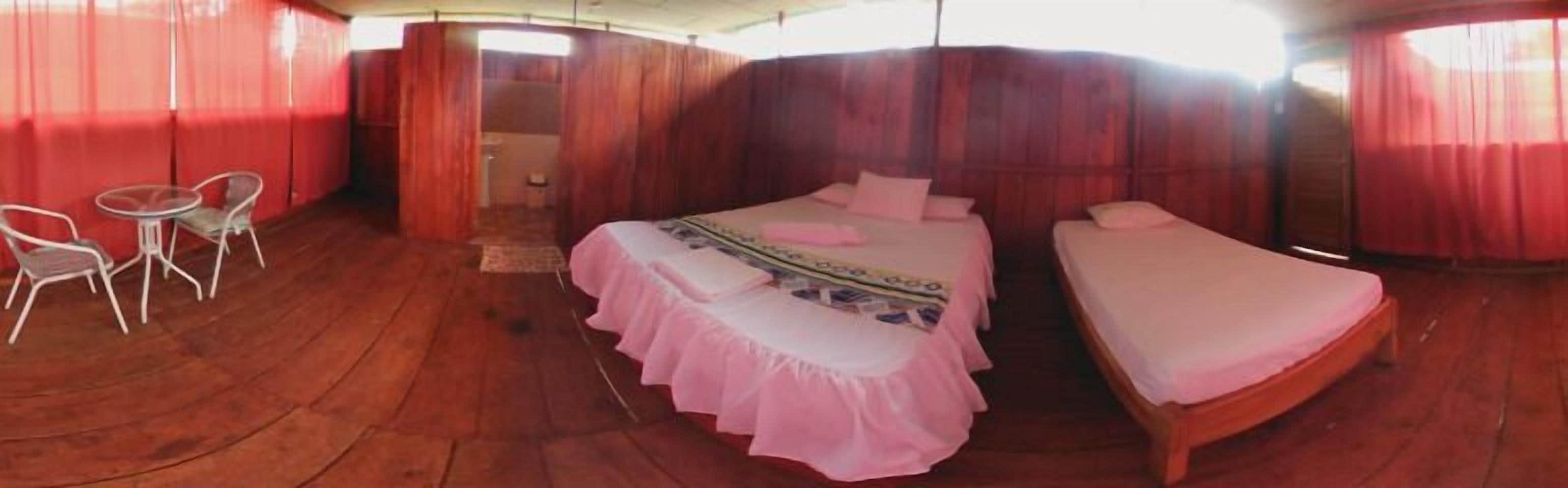 Una habitación con una cama, una cama individual y una mesa con sillas.