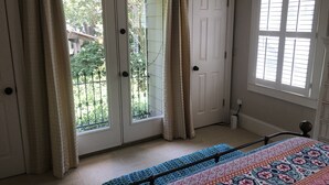 A bedroom with a bed, a window, and a door.