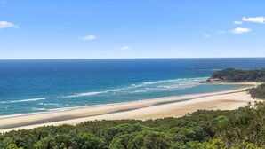 A coastal landscape with a beach, ocean, and forested area. - Beautiful Apartment built 2019 (Point Lookout)