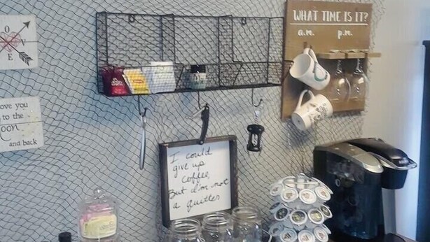 Un coin café équipé d’une machine à café, de tasses et d’une pancarte sur laquelle on peut lire : « Le café et les amis, un mélange parfait ».
