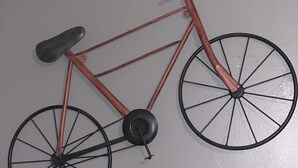 Un vélo mural avec une selle et un guidon noirs, et un cadre de couleur cuivrée.