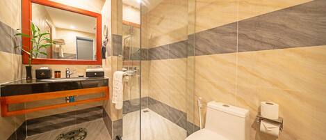 A modern bathroom with a glass-enclosed shower, a marble-tiled floor, a black countertop, and a white toilet.