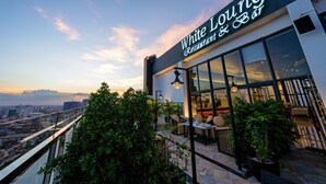 Un restaurante con vistas a la ciudad al atardecer.