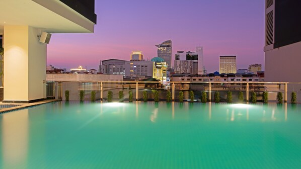 Una piscina en la azotea con un horizonte urbano de fondo.