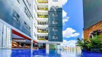 Een buitenzwembad, parasols bij het zwembad en ligstoelen