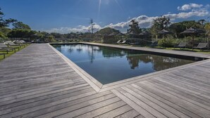 A swimming pool with a wooden deck, lounge chairs, and umbrellas. - Cala Sultana by Interhome (Porto Vecchio)