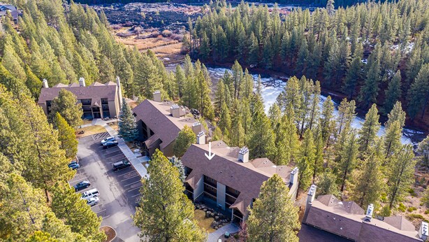 An aerial view of a lodge with multiple buildings, a parking lot, and a river. - Stunning Views, Closest to Mt. Bachelor, Resort Amenities & Year-Round Fun! (Bend)