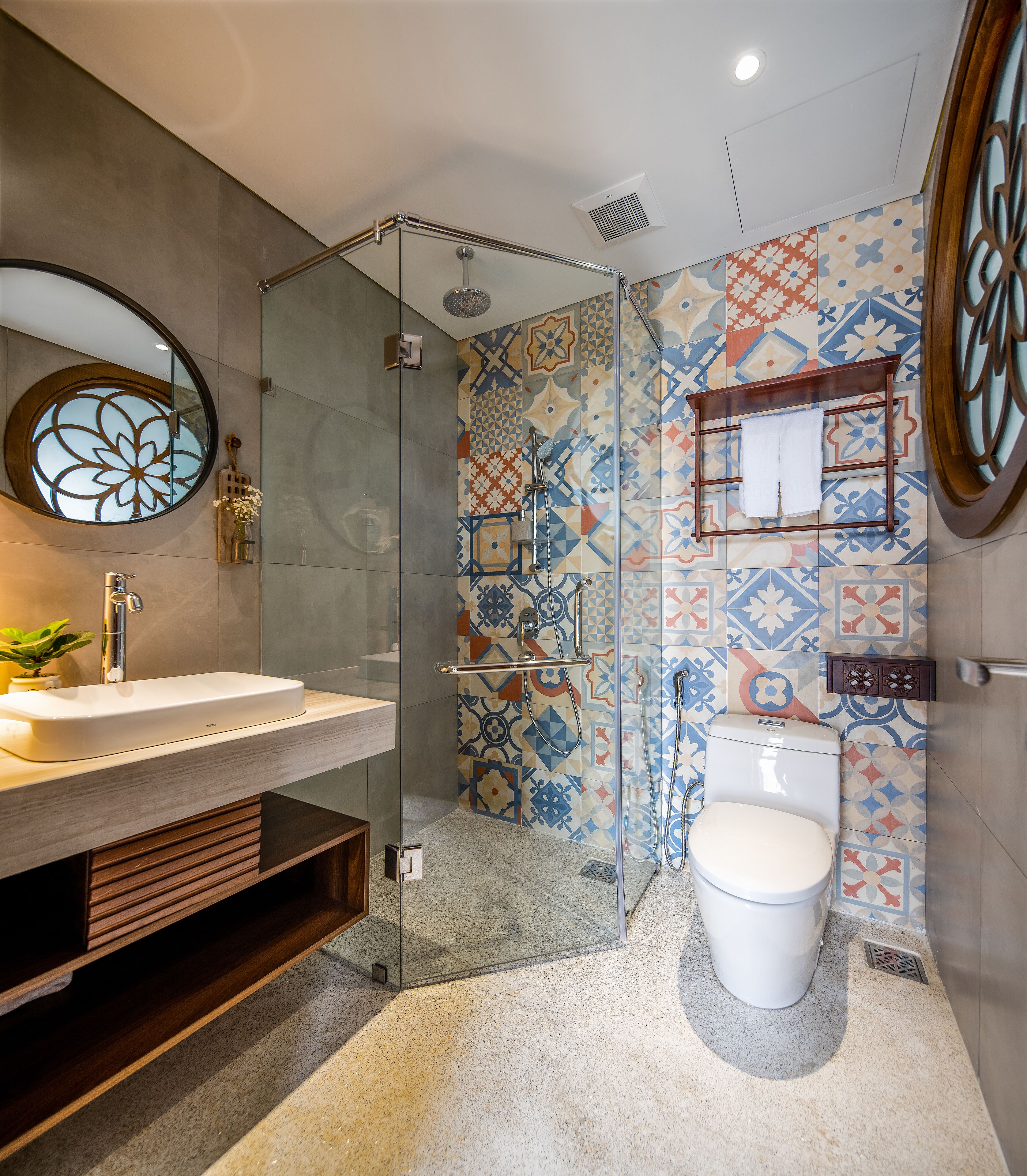 Une salle de bain moderne avec une douche à parois de verre, des toilettes blanches et un lavabo avec un meuble-vasque en bois.
