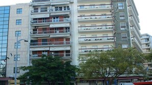 Ein mehrstöckiges Hotel mit Balkonen, einem Parkplatz und Blick auf die Straße.