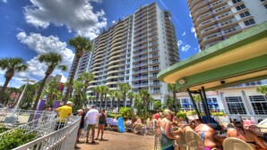 A resort with high-rise buildings, outdoor seating areas, and palm trees.