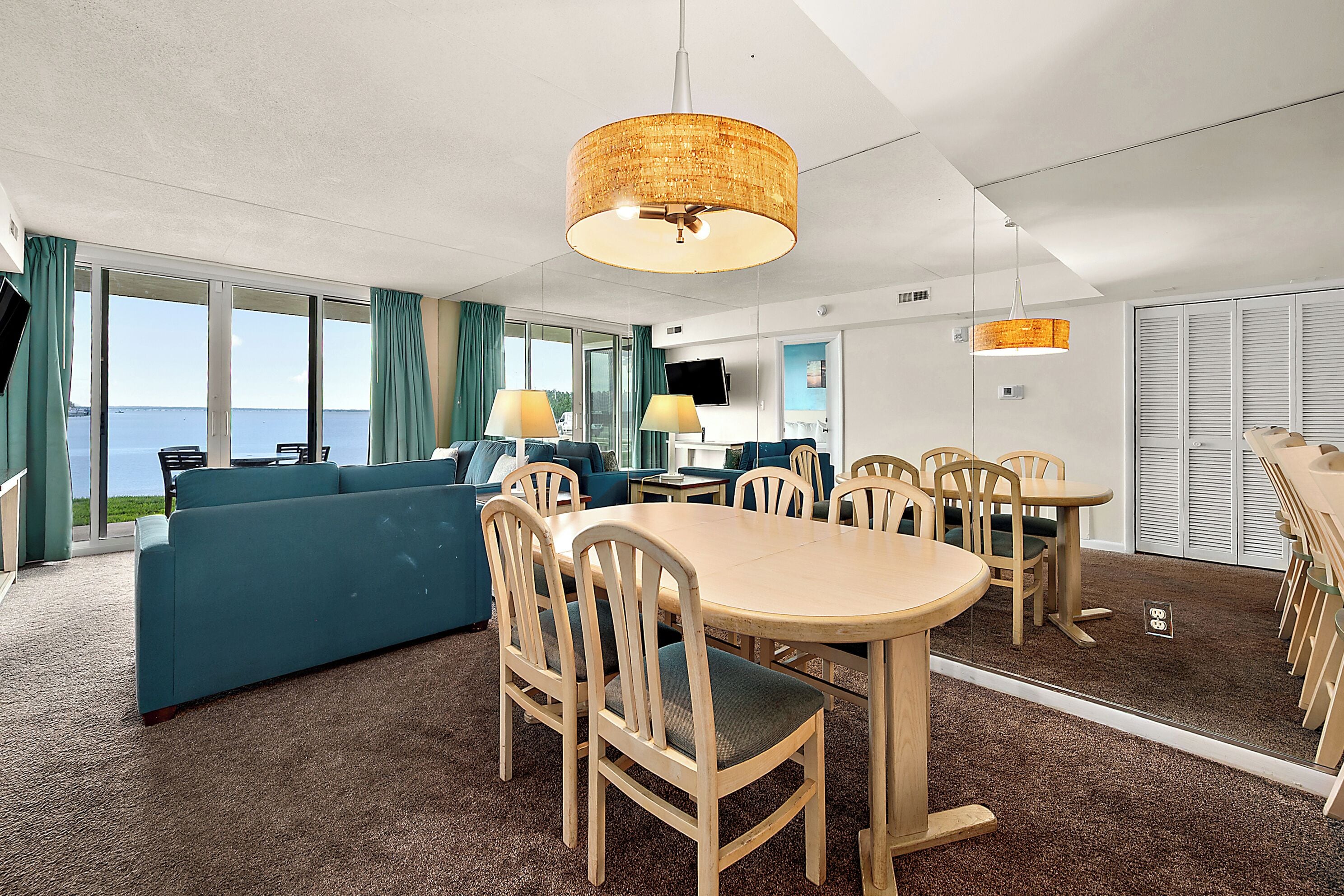 Une chambre d’hôtel dotée d’une grande fenêtre, d’un canapé, d’une table à manger avec des chaises et d’un téléviseur.