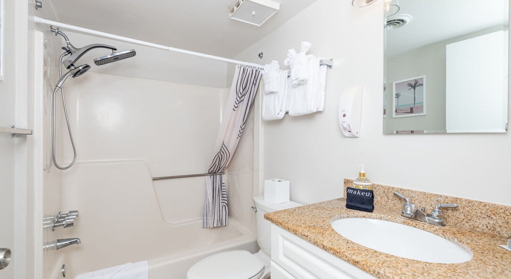 Une salle de bain équipée d’une douche, de toilettes, d’un lavabo et d’un porte-serviettes avec plusieurs serviettes.