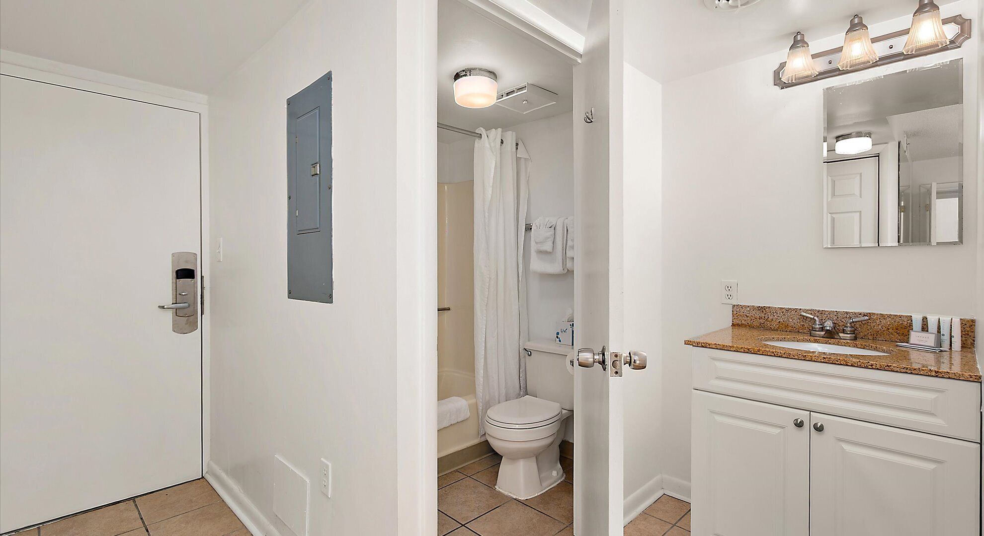 Een badkamer met toilet, douche en wastafel.
