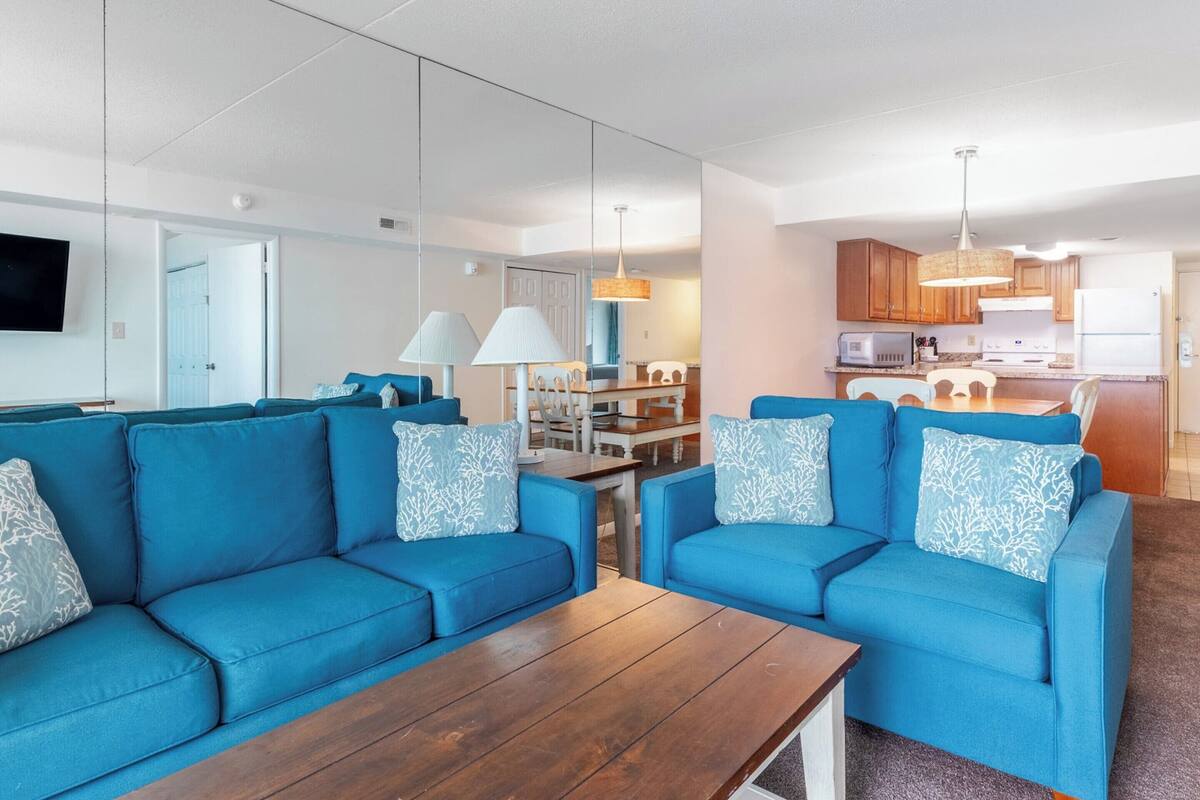 Ein modernes Wohnzimmer mit blauen Sofas und einem Holztisch.