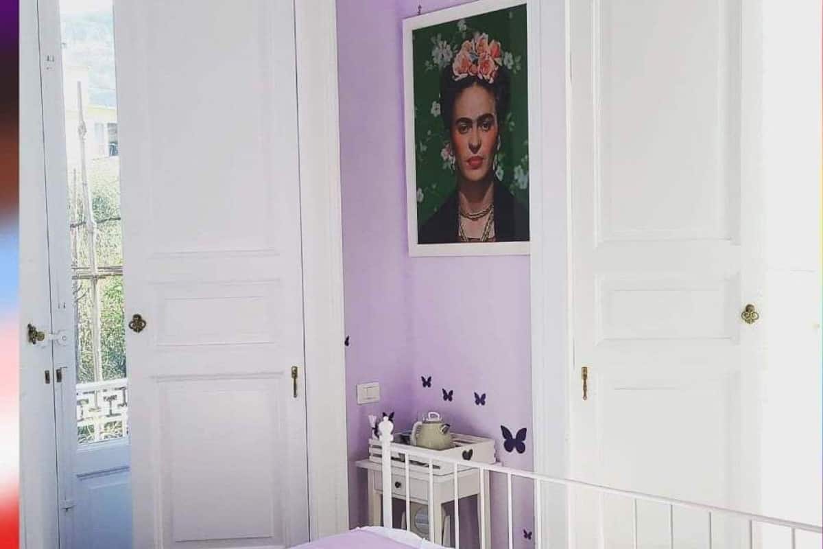 A bedroom with a bed, a dresser, and a wall-mounted picture.