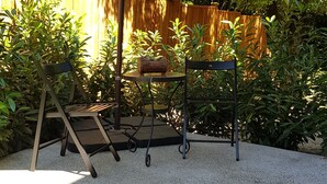 An outdoor patio area with a swing set, a table, and an umbrella. - Modern condo near Microsoft for business and leisure travelers (Bellevue)