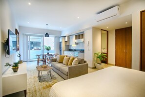 A modern hotel room with a large bed, a sofa, a dining table, and a kitchen area. - Romantic Zone Gem | 2 Pools, Gym | Walk to Beach (Puerto Vallarta)