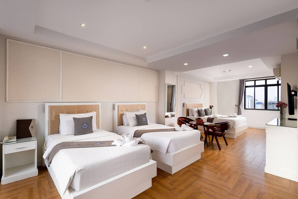 Ein Hotelzimmer mit zwei Betten, einem Schreibtisch und einem Stuhl.