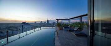 Una piscina al aire libre, sillones reclinables de piscina