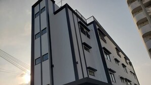 A multi-story building with a modern architectural design, featuring a flat roof and a mix of rectangular and square windows. - Ocean View Araha 201 (Chatan)