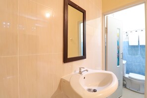 A bathroom with a white sink, a mirror, and a toilet. - Hotel O Kenanga Homestay (Nusa Dua)
