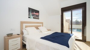 A bedroom with a bed, a nightstand, a painting, and a sliding glass door to a pool. - Villa Stachera (San Pedro del Pinatar) (San Pedro del Pinatar)