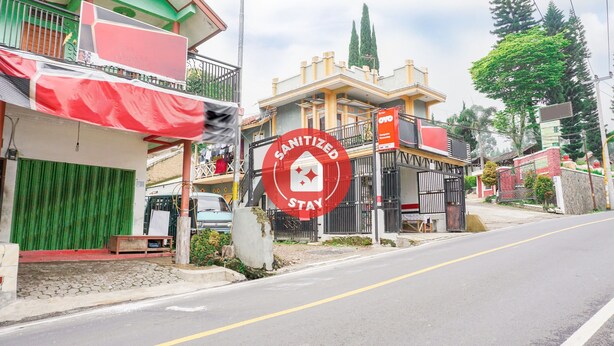 A street view with a building labeled "Sanitized Stay" and a sign indicating it is a hotel. - OYO 2369 Cempaka Homestay (Rancabali)