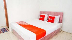 A bed with a red and white bedspread, two red pillows with "OYO" text, and a red blanket. - OYO 2369 Cempaka Homestay (Rancabali)