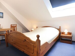 Une chambre à coucher avec un lit en bois, un bureau et une chaise.