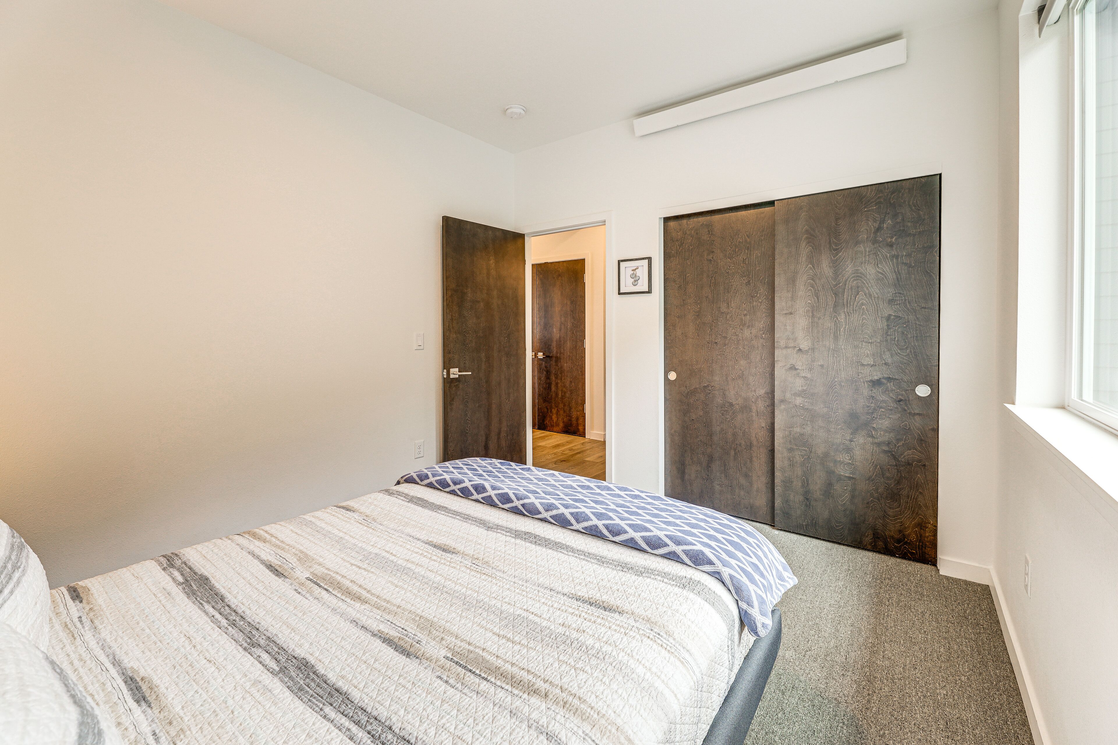 Une chambre à coucher avec un lit, une armoire et une fenêtre.